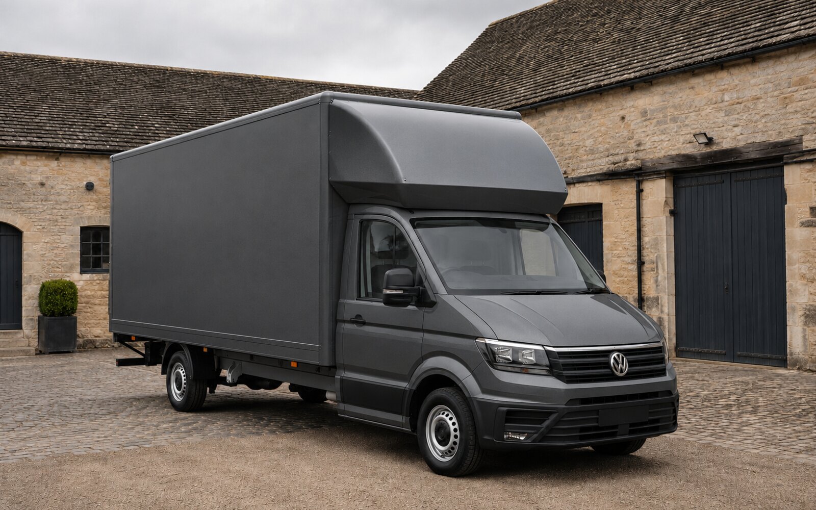 Grey Volkswagen Crafter Luton outside Cotswolds stone buildings